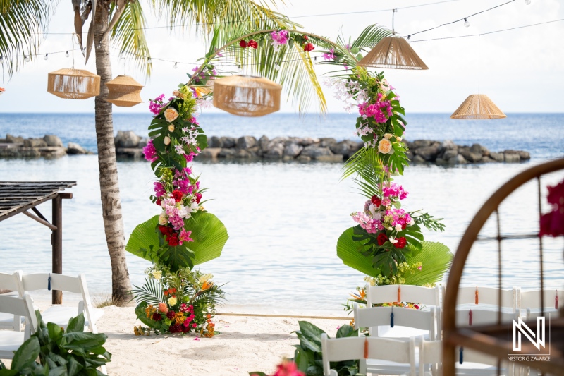 Wedding ceremony setup at Avila Beach Hotel in Curacao with floral decorations and scenic beachfront view