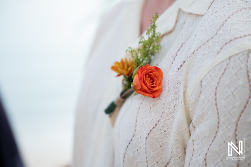 Wedding ceremony at Avila Beach Hotel in Curacao with orange rose boutonniere on groom's shirt