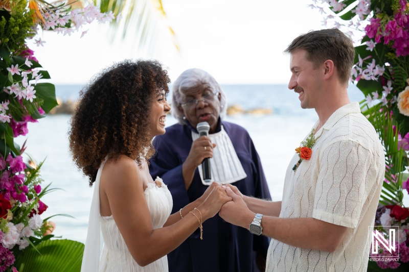 Wedding ceremony at Avila Beach Hotel in Curacao with couple exchanging vows and officiant speaking to guests