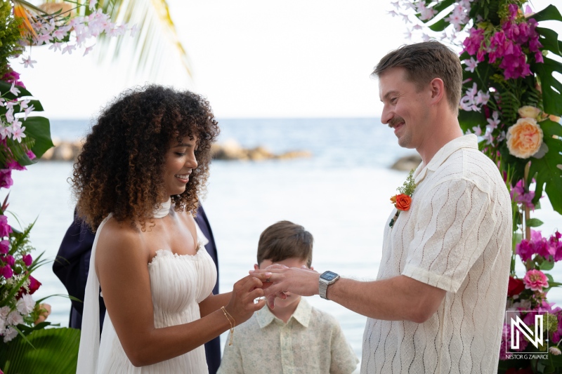 Couple exchanges rings during wedding ceremony at Avila Beach Hotel in Curacao in warm weather