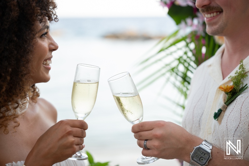 Couple celebrates their wedding at Avila Beach Hotel in Curacao with champagne toast by the sea