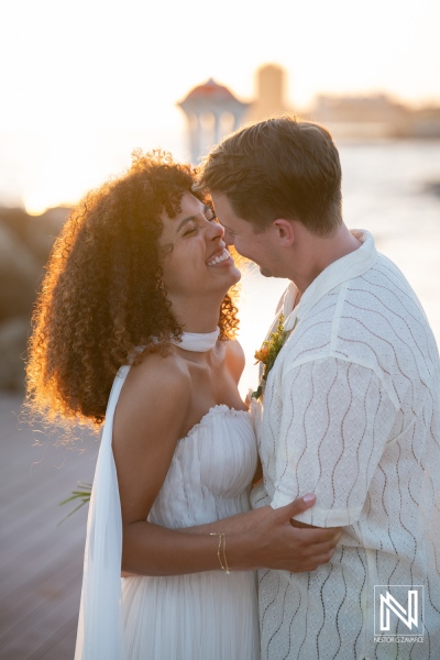 Couple enjoys a romantic moment during a wedding ceremony at Avila Beach Hotel in Curacao with a sunset backdrop