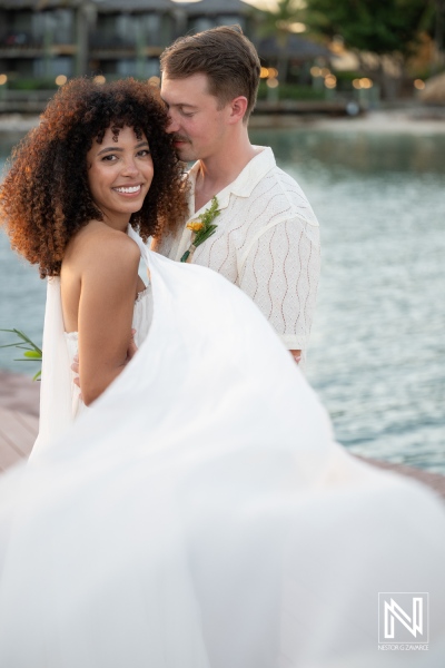 Couple celebrates their wedding at Avila Beach Hotel in Curacao during sunset by the water