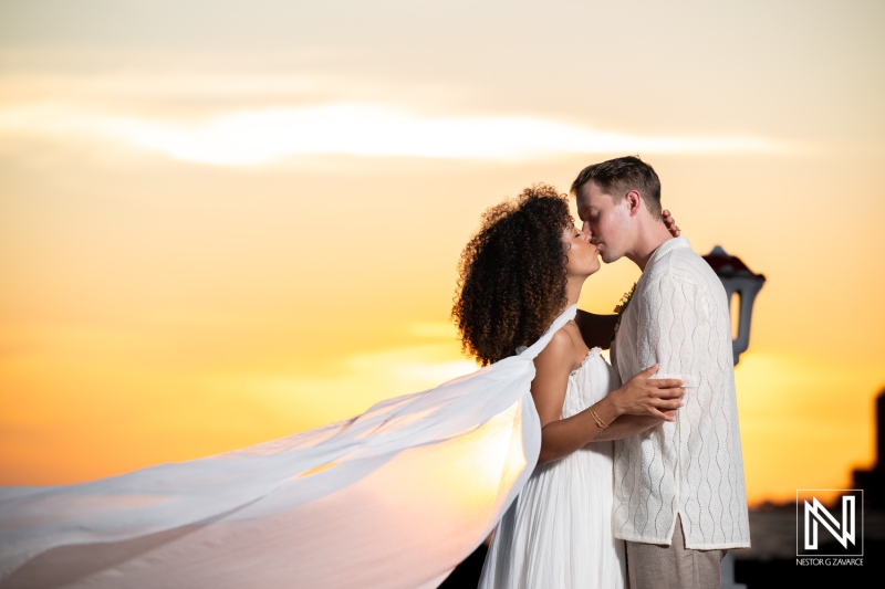 Couple shares a kiss during their wedding celebration at Avila Beach Hotel in Curacao at sunset