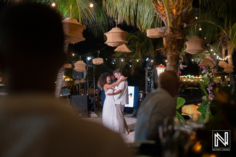 Couple dances at wedding celebration in Curacao under lights at Avila Beach Hotel