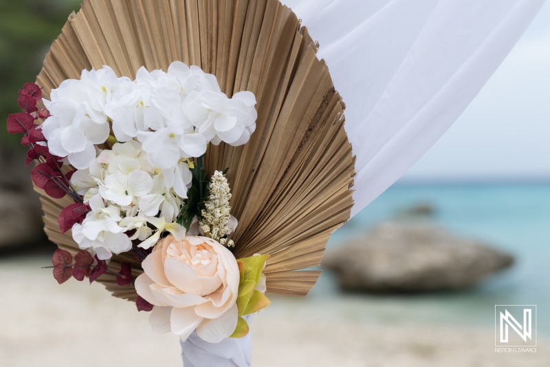 Destination wedding celebration at Daaibooi Beach in Curacao with beautiful floral arrangements and a tropical backdrop