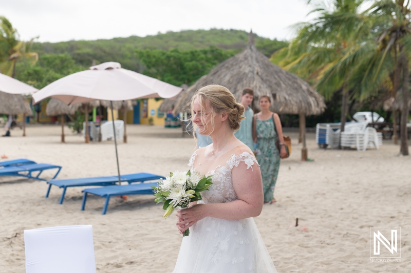 Dreamy beach wedding ceremony on Daaibooi Beach in Curacao as the bride approaches the altar