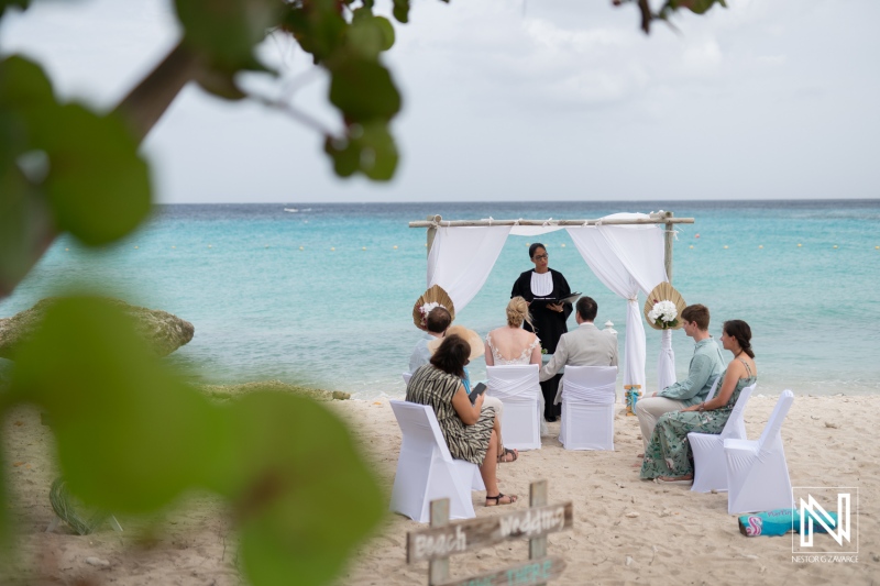 Destination wedding ceremony at Daaibooi Beach in Curacao with beautiful ocean backdrop and guests in elegant attire