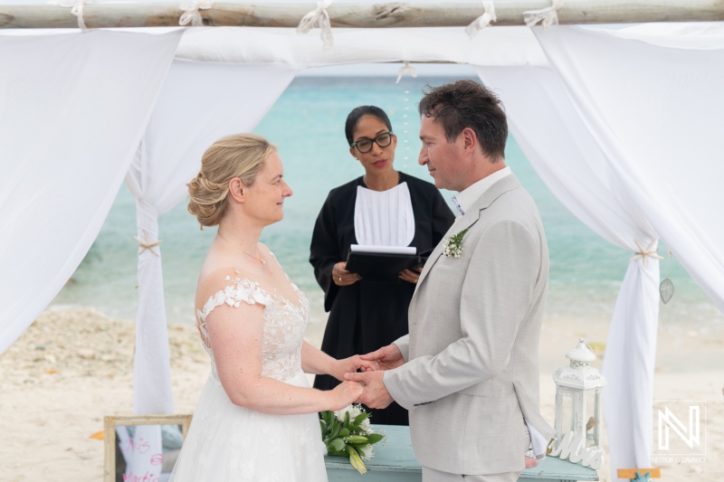 Couple exchanges vows on Daaibooi Beach in Curacao during a romantic destination wedding ceremony