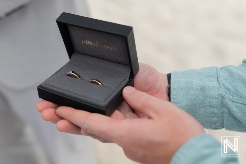 Wedding rings presented during a destination wedding ceremony at Daaibooi Beach in Curacao