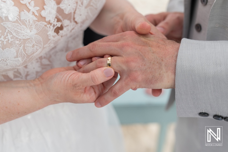 Couple exchanges wedding rings at Daaibooi Beach in Curacao during a romantic beach ceremony