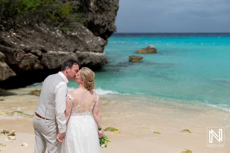 Couple shares a romantic kiss during their destination wedding at Daaibooi Beach in Curacao on a beautiful sunny day