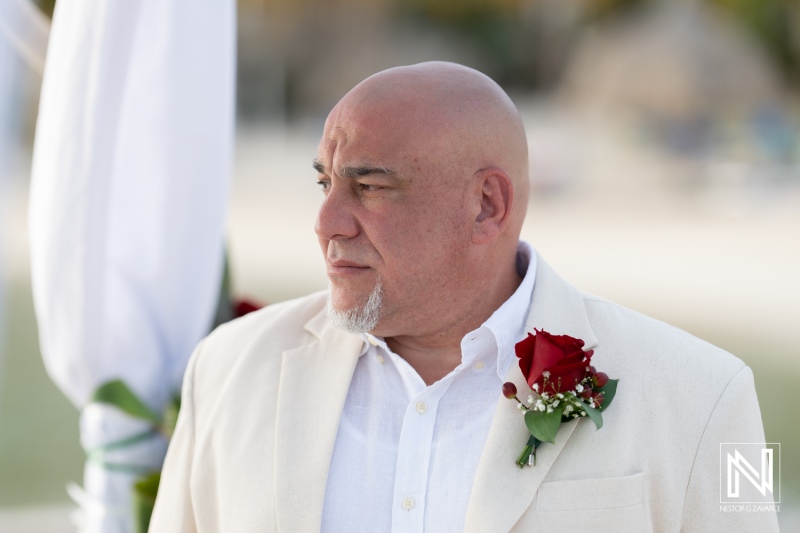 Groom waiting for his bride at a beautiful wedding ceremony in Curacao's Sunscape resort with scenic beach backdrop and soft sunset lighting