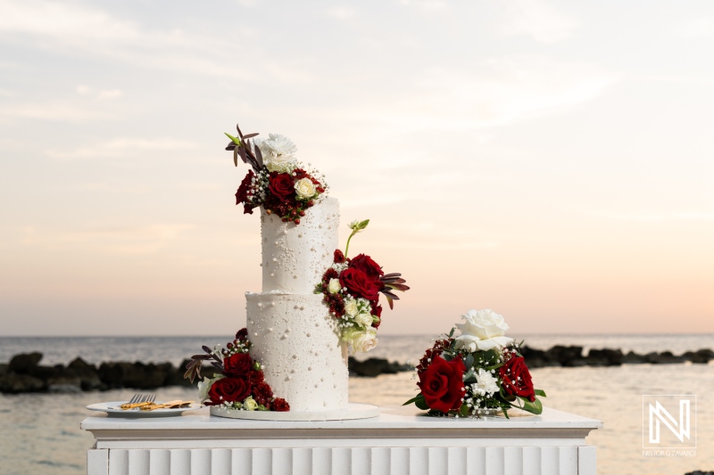 Elegant wedding cake adorned with roses at Sunscape Curacao Resort during a romantic sunset