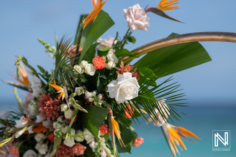 Wedding ceremony adornments at a sunset celebration in Curacao surrounded by elegant floral arrangements at the beachfront venue