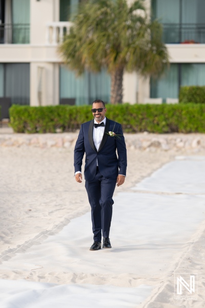 Groom walking towards the altar at a sunset wedding ceremony in Curacao Marriott Beach Resort