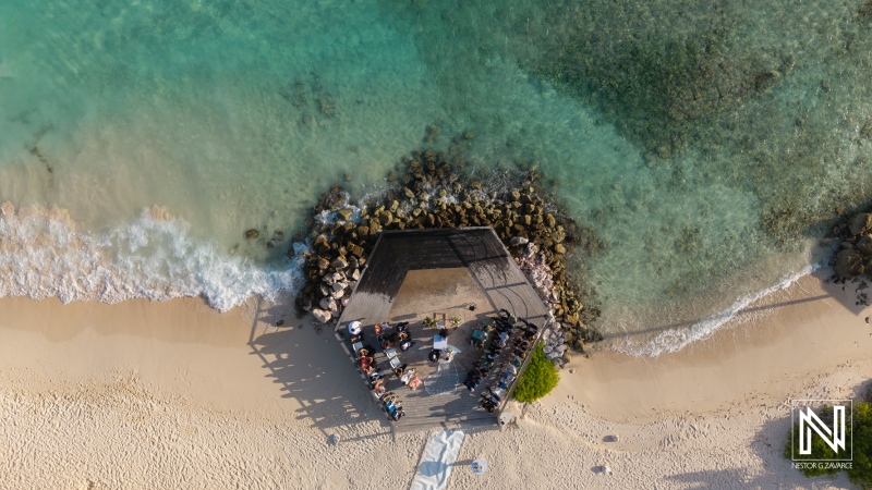 Sunset wedding ceremony at a beachfront venue in Curacao Marriott Beach Resort surrounded by family and friends