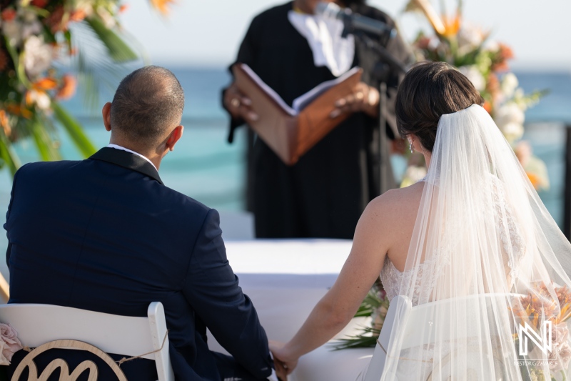 Couple exchanges vows during a romantic sunset wedding ceremony at Curacao Marriott Beach Resort in a breathtaking tropical setting
