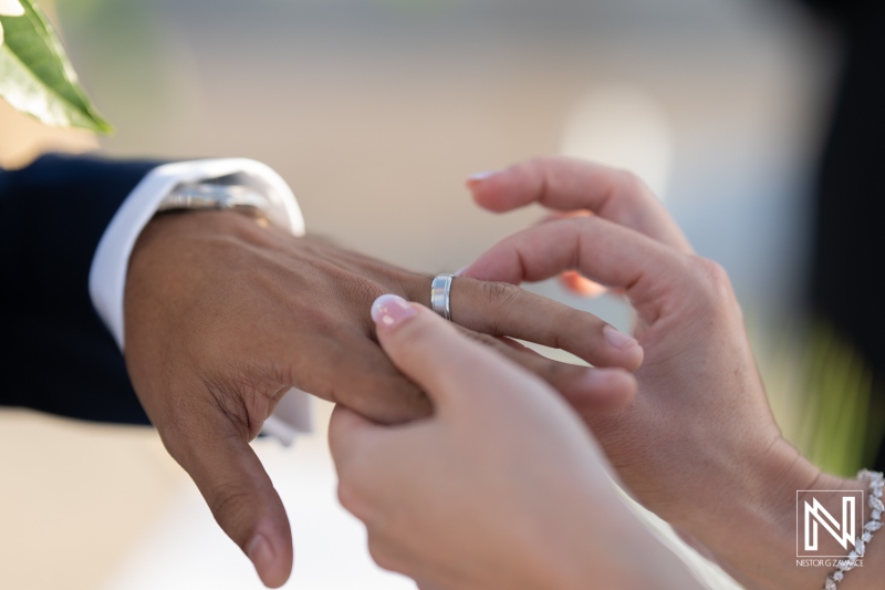 Couple exchanges wedding rings during sunset ceremony at a tropical beach resort in Curacao