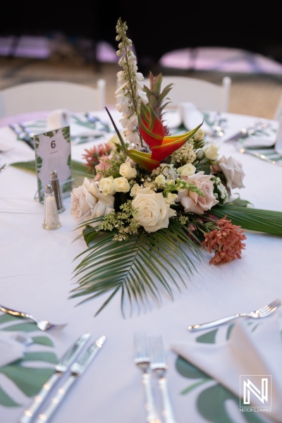 Elegant floral centerpiece enhances wedding reception at Curacao Marriott Beach Resort during a romantic sunset