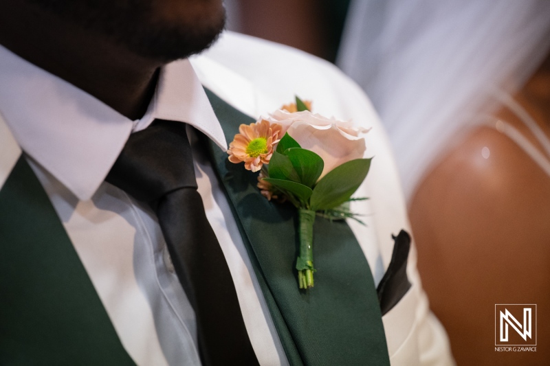 Wedding celebration at Avila Beach Hotel in Curacao with close-up of groom's boutonniere and flower details