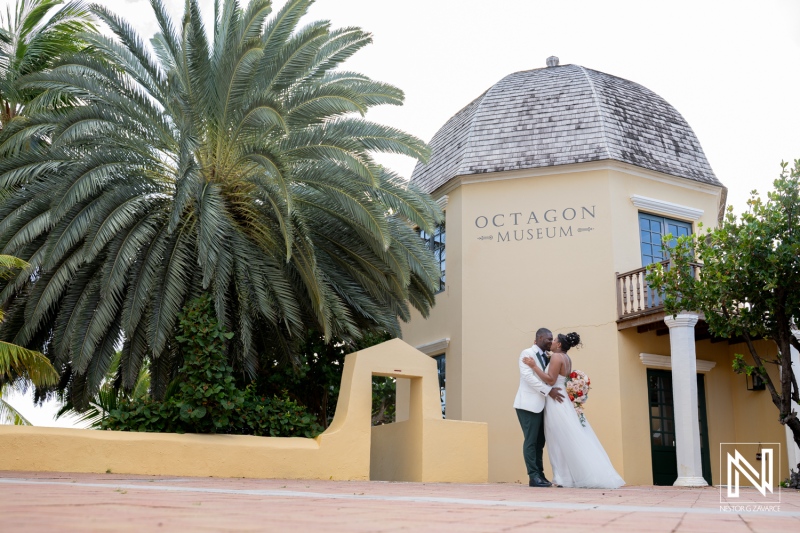 Couple shares a moment outside the Octagon Museum at Avila Beach Hotel during their wedding ceremony in Curacao
