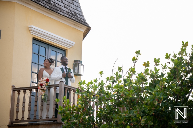 Couple stands on balcony at Avila Beach Hotel during their wedding ceremony in Curacao
