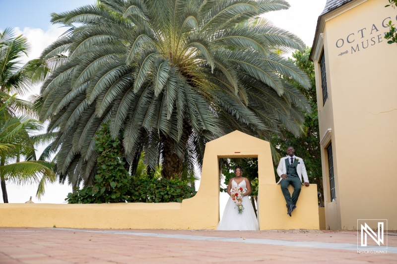 Wedding ceremony at Avila Beach Hotel in Curacao with couple posing by palm trees