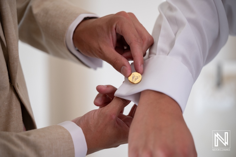 Wedding ceremony preparation at Dreams Curacao Resort, Spa and Casino with a focus on cufflink fastening