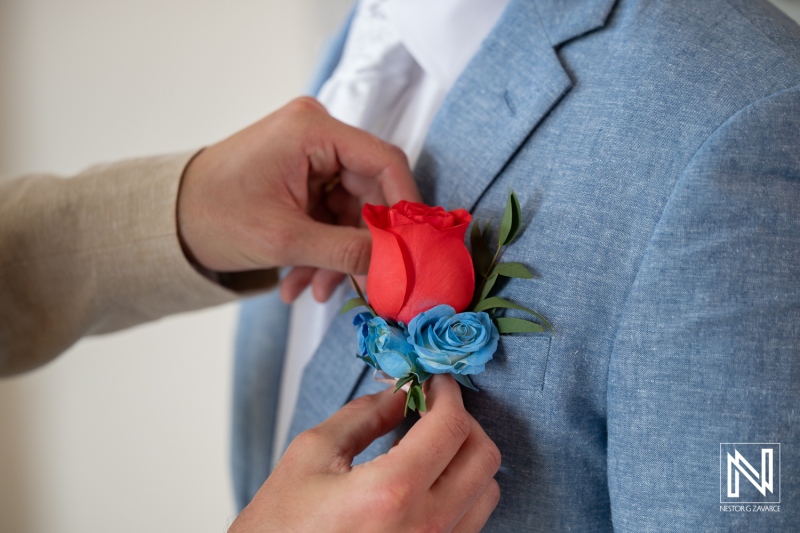 Groom getting ready for wedding ceremony at Dreams Curacao Resort, Spa Casino with boutonniere in hand