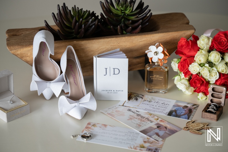 Wedding preparation at Dreams Curacao Resort Spa Casino featuring shoes, invitations, and flowers for Jocelyn and David
