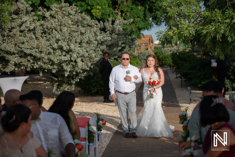 Couple walks down the aisle during wedding ceremony at Dreams Curacao Resort and Spa in Curacao, surrounded by guests and nature