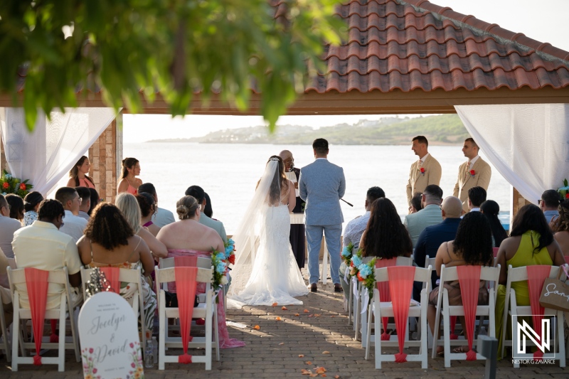 Wedding ceremony at Dreams Curacao Resort by the water with guests in attendance