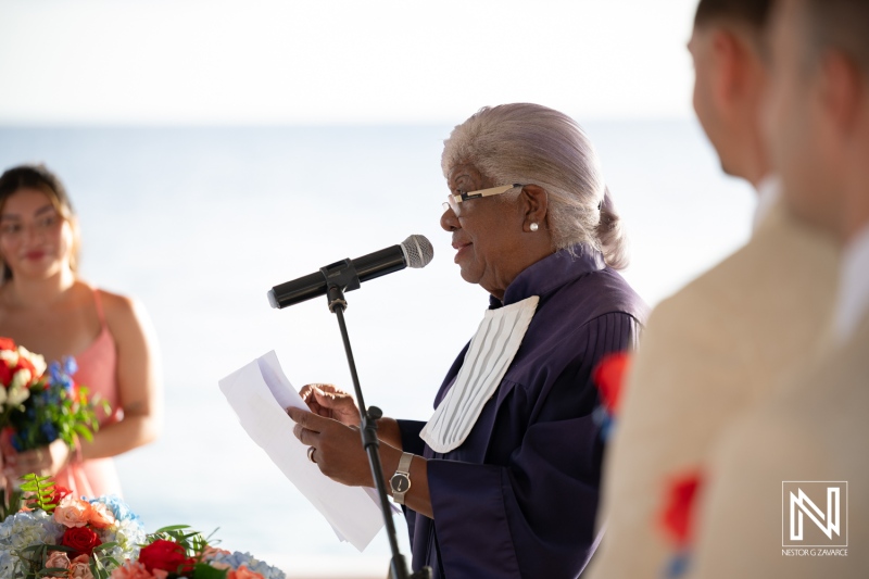 Ceremony at Dreams Curacao Resort with officiant speaking to couple by the ocean