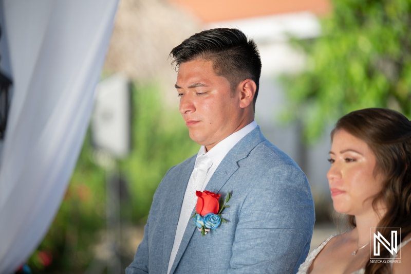 Wedding ceremony at Dreams Curacao Resort with couple standing together under arch