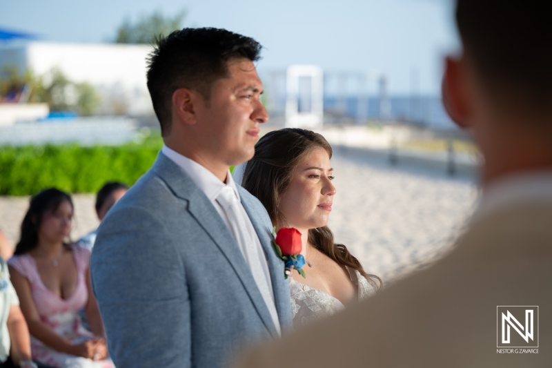 Couple exchanges vows during their wedding ceremony at Dreams Curacao Resort, Spa and Casino on a sunny day by the beach