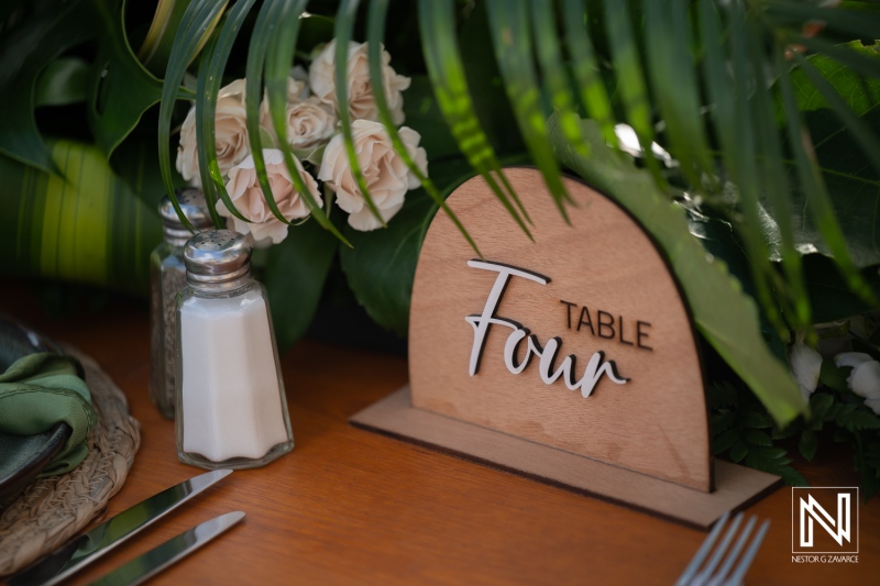 Wedding table setting at Renaissance Wind Creek in Curacao with a wooden sign indicating table four