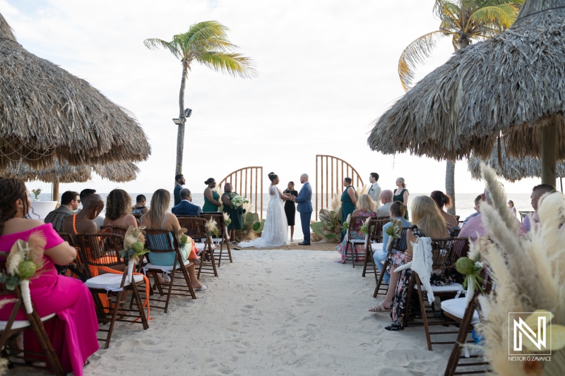 Wedding ceremony at Renaissance Wind Creek with guests by the beach in Curacao during sunset