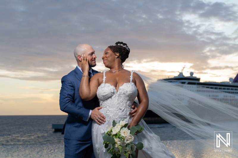Couple celebrates wedding at Renaissance Wind Creek in Curacao during sunset with cruise ship in background