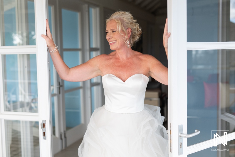 Joyful bride embracing her special day at Papagayo Beach Resort in Curacao as she steps outside