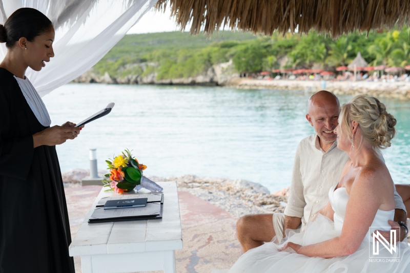 Intimate wedding ceremony at Karakter beach in Curacao with joyful couple exchanging vows by the water