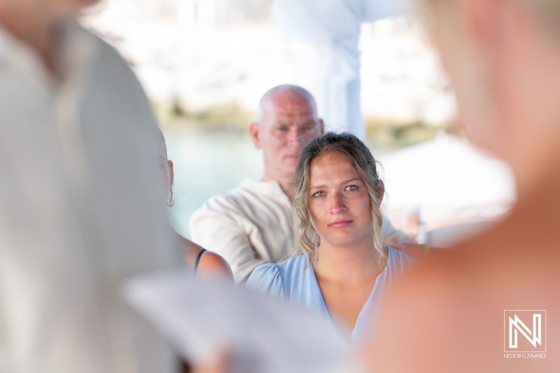 Couple exchanges vows during a beautiful wedding ceremony at Karakter beach in Curacao, surrounded by friends and family in a stunning outdoor setting