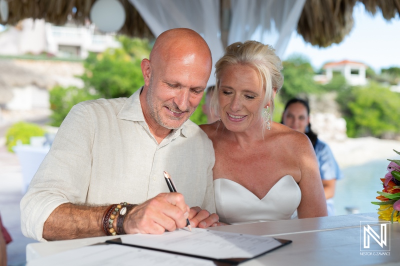 Couple signs wedding documents at Karakter in Curacao during a tropical celebration