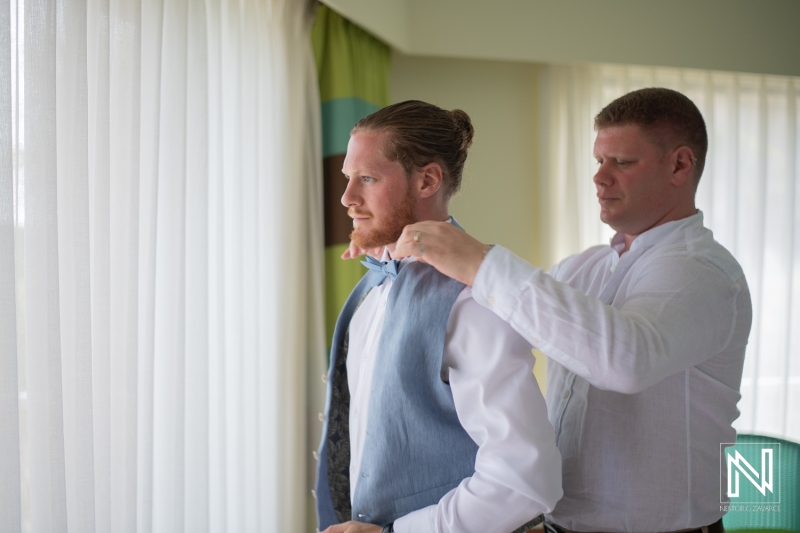 Groom getting into attire