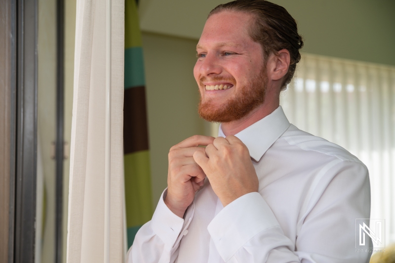 Groom getting into attire