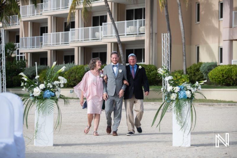 Groom, dad and mom walking down the isle