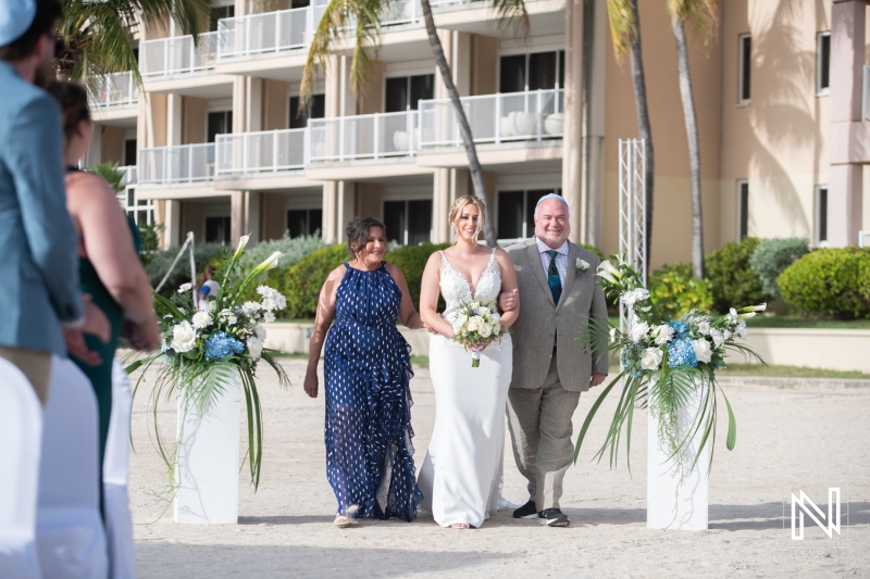 Bride, mom and dad walking down the isle