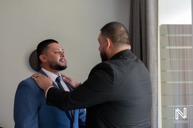 Groom getting ready for wedding ceremony at Avila Beach Hotel in Curacao with close friend assisting