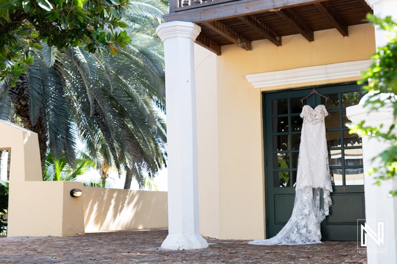 Beautiful wedding dress elegantly displayed at Avila Beach Hotel in Curacao, surrounded by lush greenery, perfect for a romantic ceremony setting