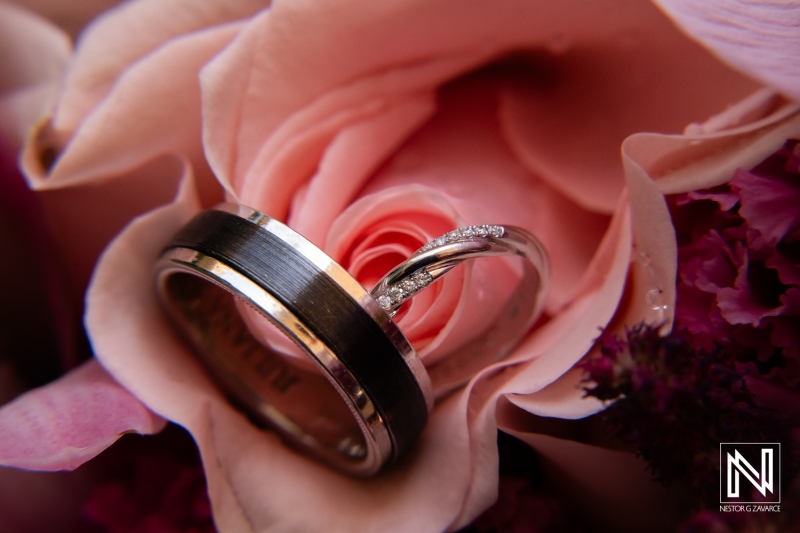 Wedding rings nestled among soft pink roses at the Avila Beach Hotel in Curacao during a beautiful wedding celebration